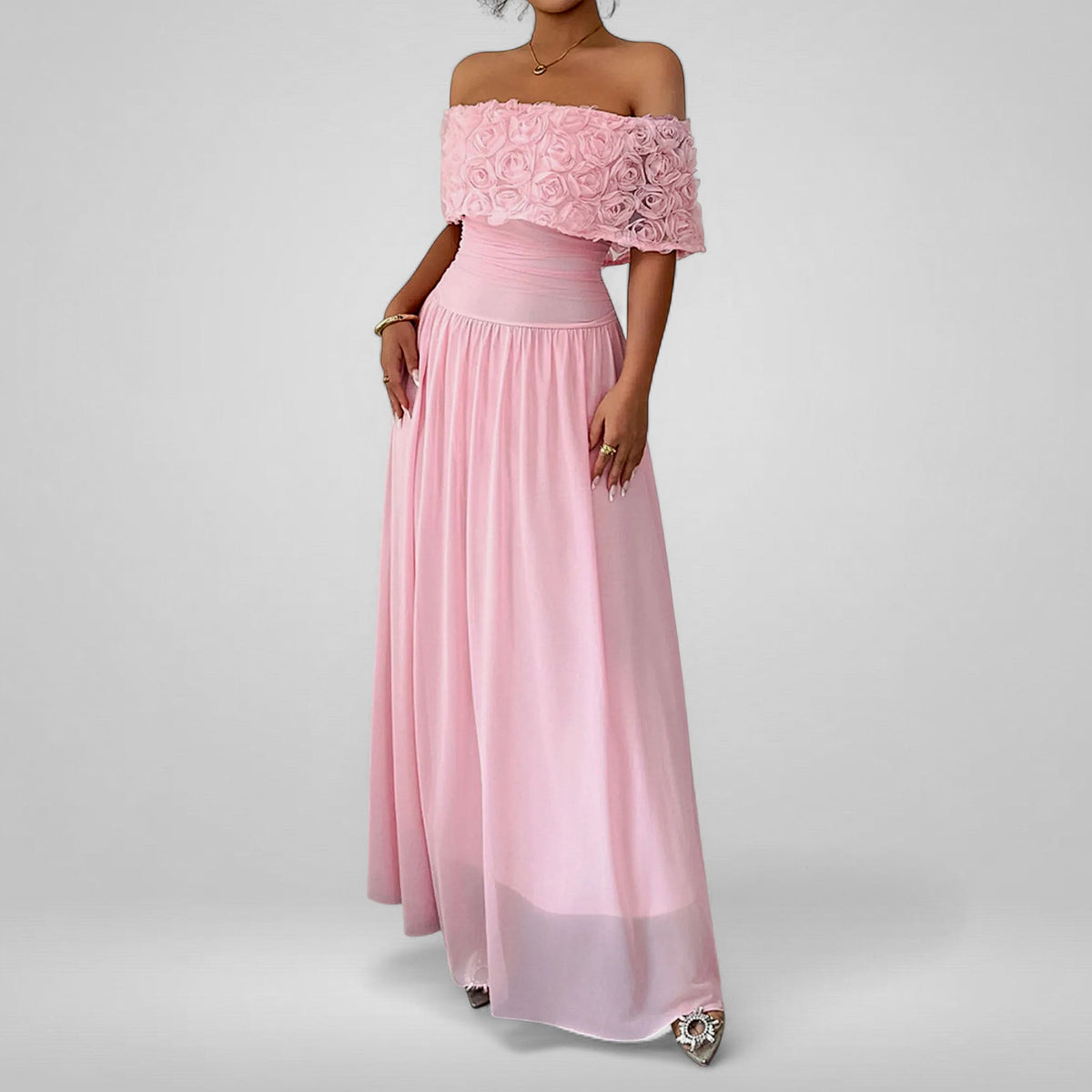 Pink off-shoulder gown with floral details on a gray background