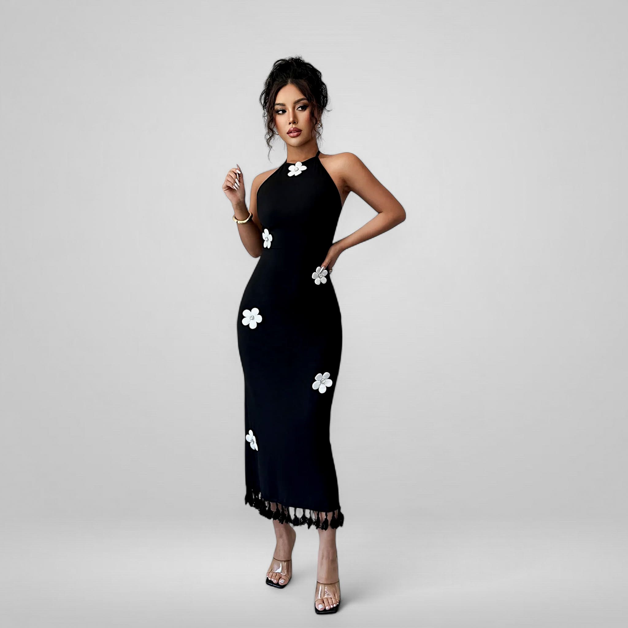 Woman wearing a black dress with white floral patterns on a gray background