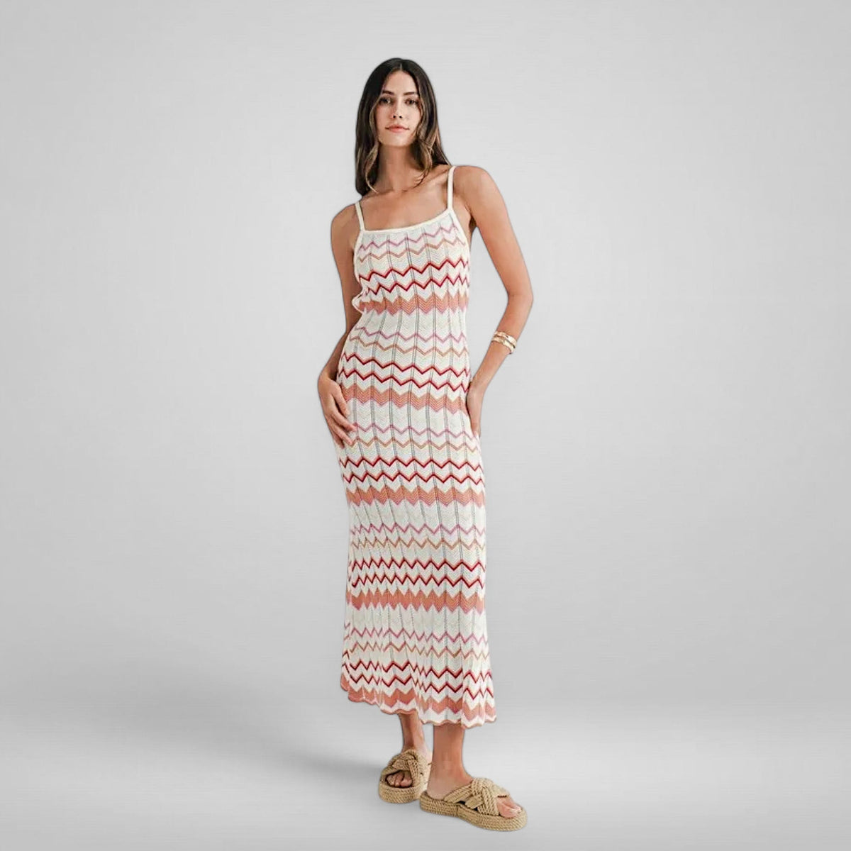 Woman wearing a zigzag patterned dress on a plain background
