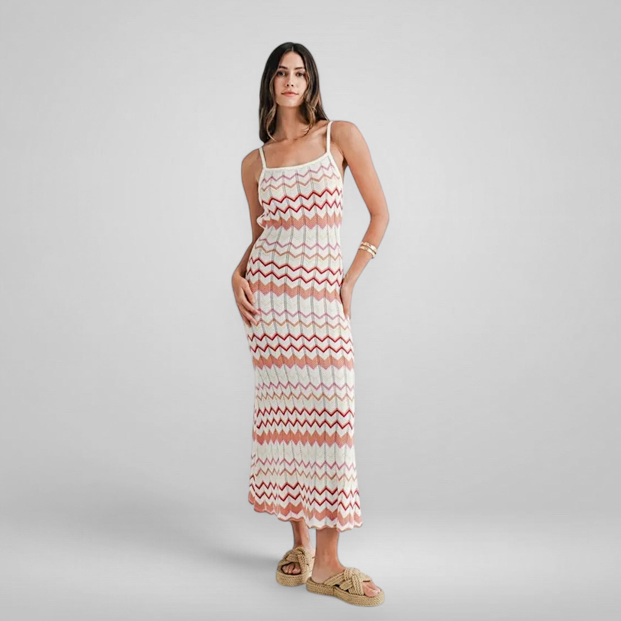 Woman wearing a zigzag patterned dress on a plain background