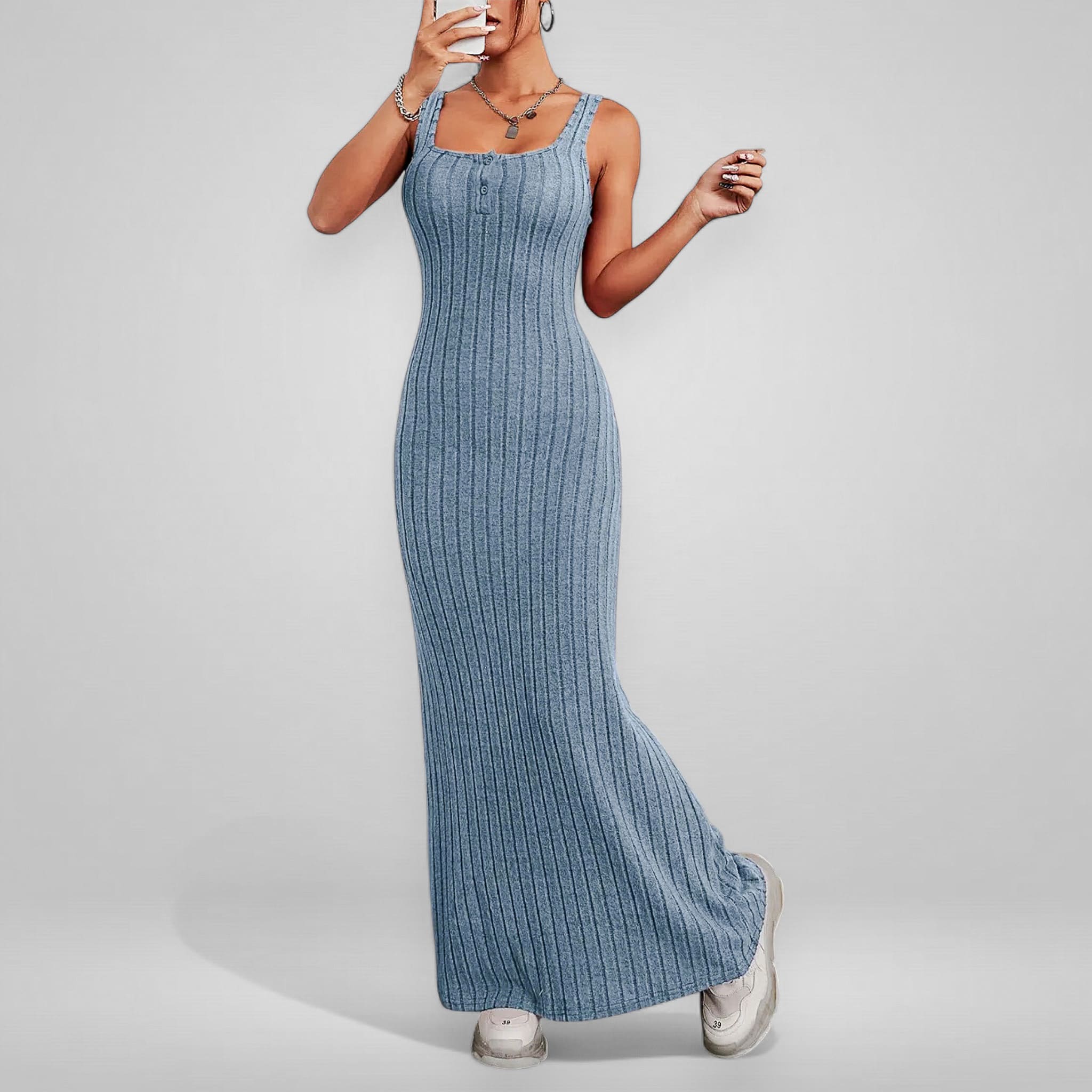 Woman wearing a blue ribbed dress against a plain background
