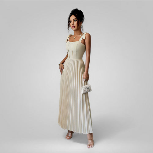Woman wearing a beige pleated dress on a gray background