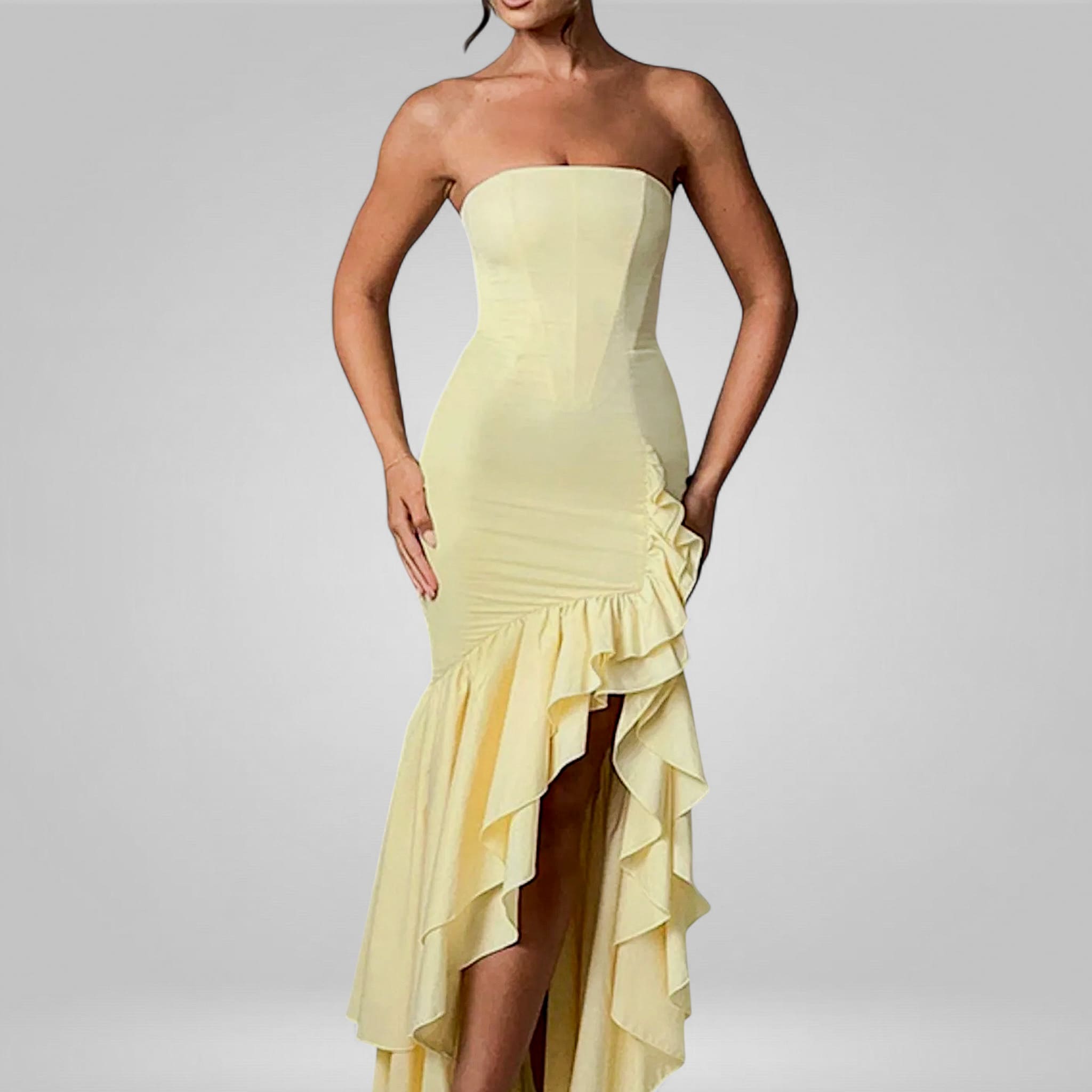 Yellow strapless dress with ruffled skirt on a gray background