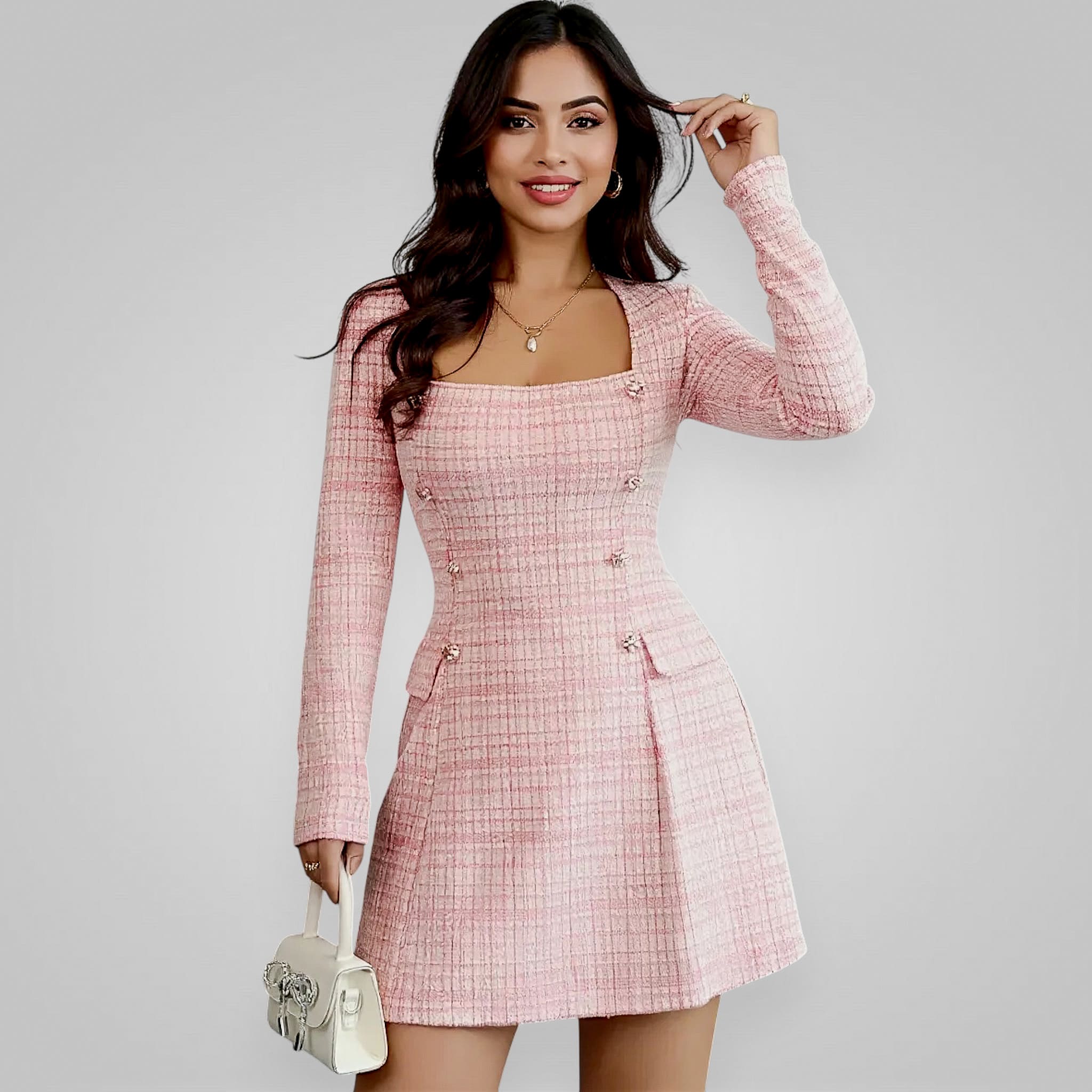 Woman wearing a pink checkered dress against a gray background