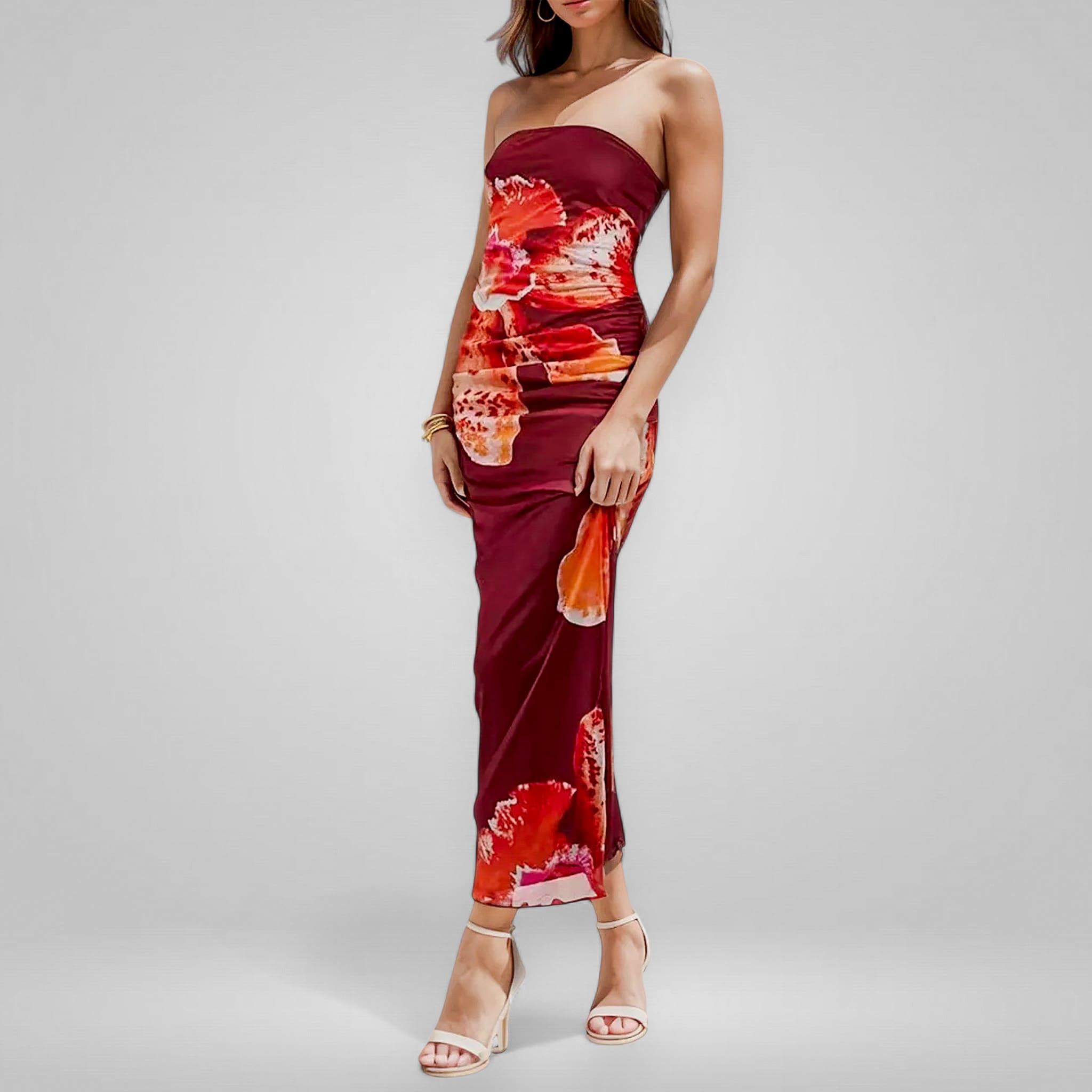 Woman wearing a strapless dress with floral pattern on a plain background