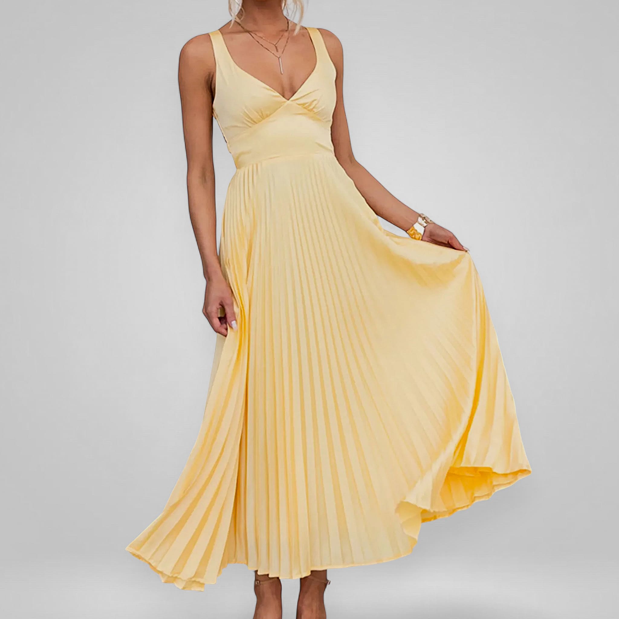 Yellow pleated dress on a plain background