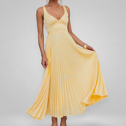 Yellow pleated dress on a plain background