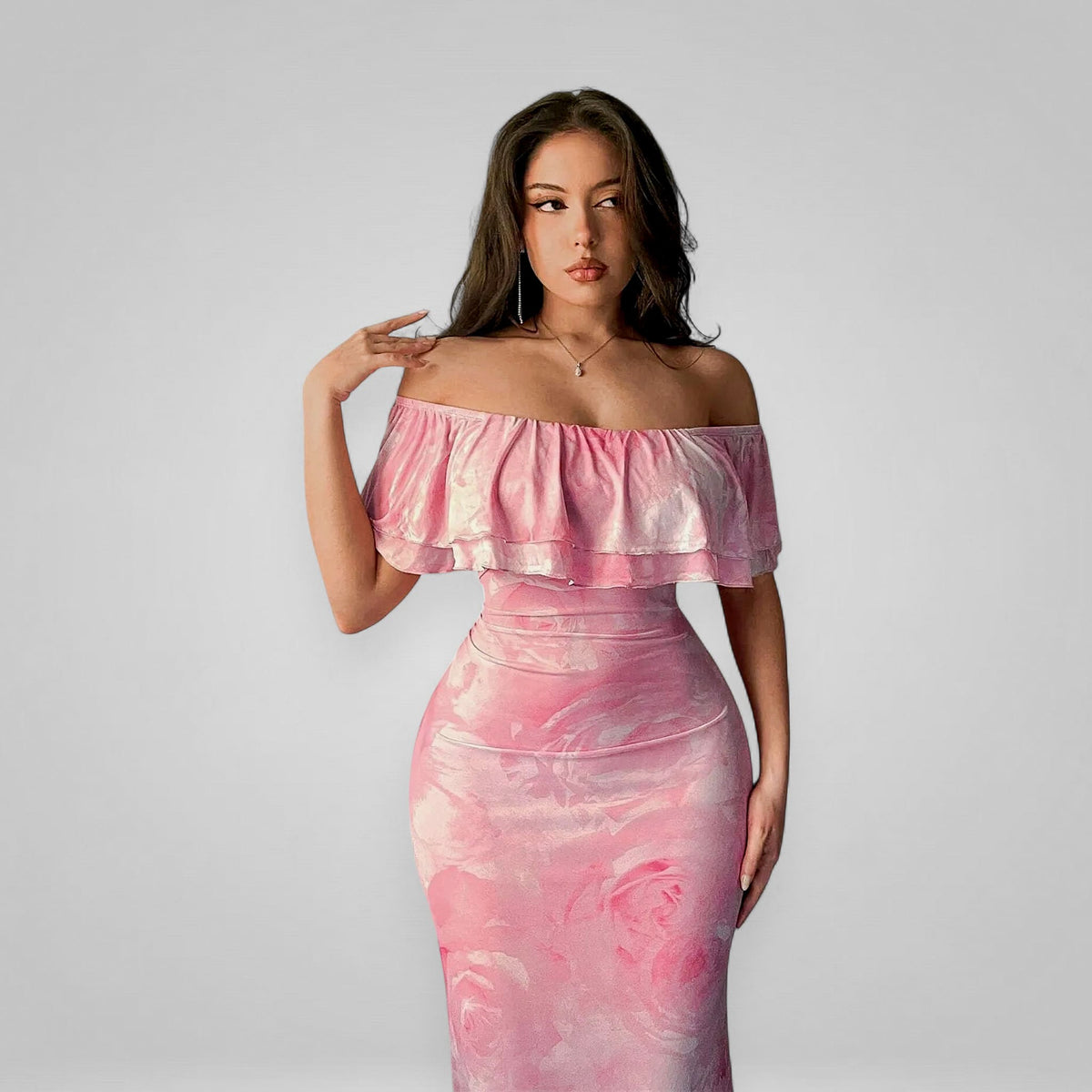 Woman wearing a pink off-shoulder dress against a plain background
