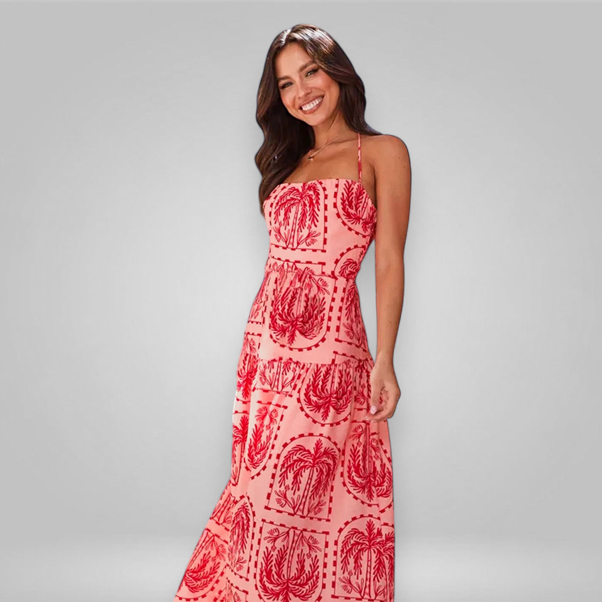 Woman wearing a pink dress with red patterns on a gray background