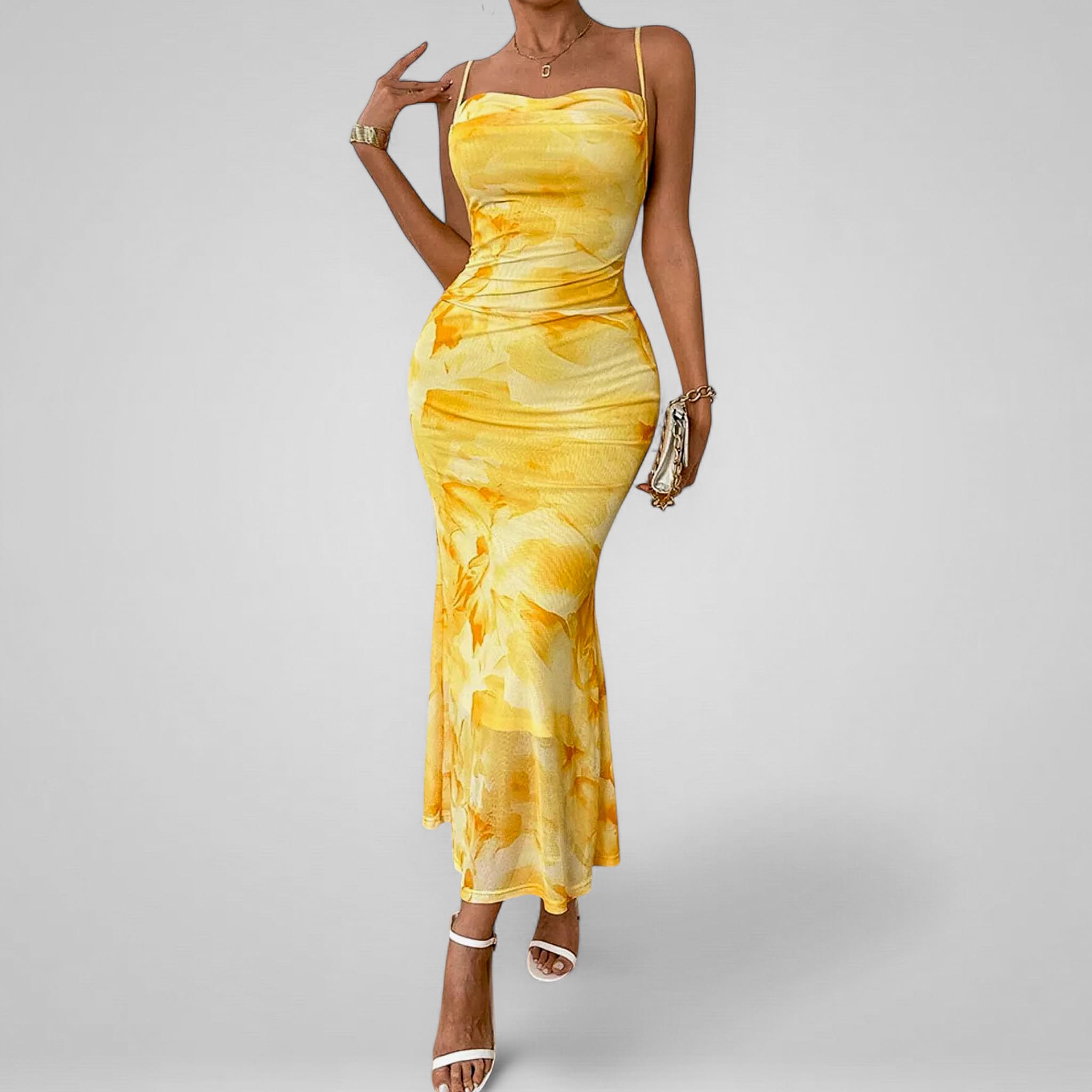 Woman wearing a yellow tie-dye dress on a gray background