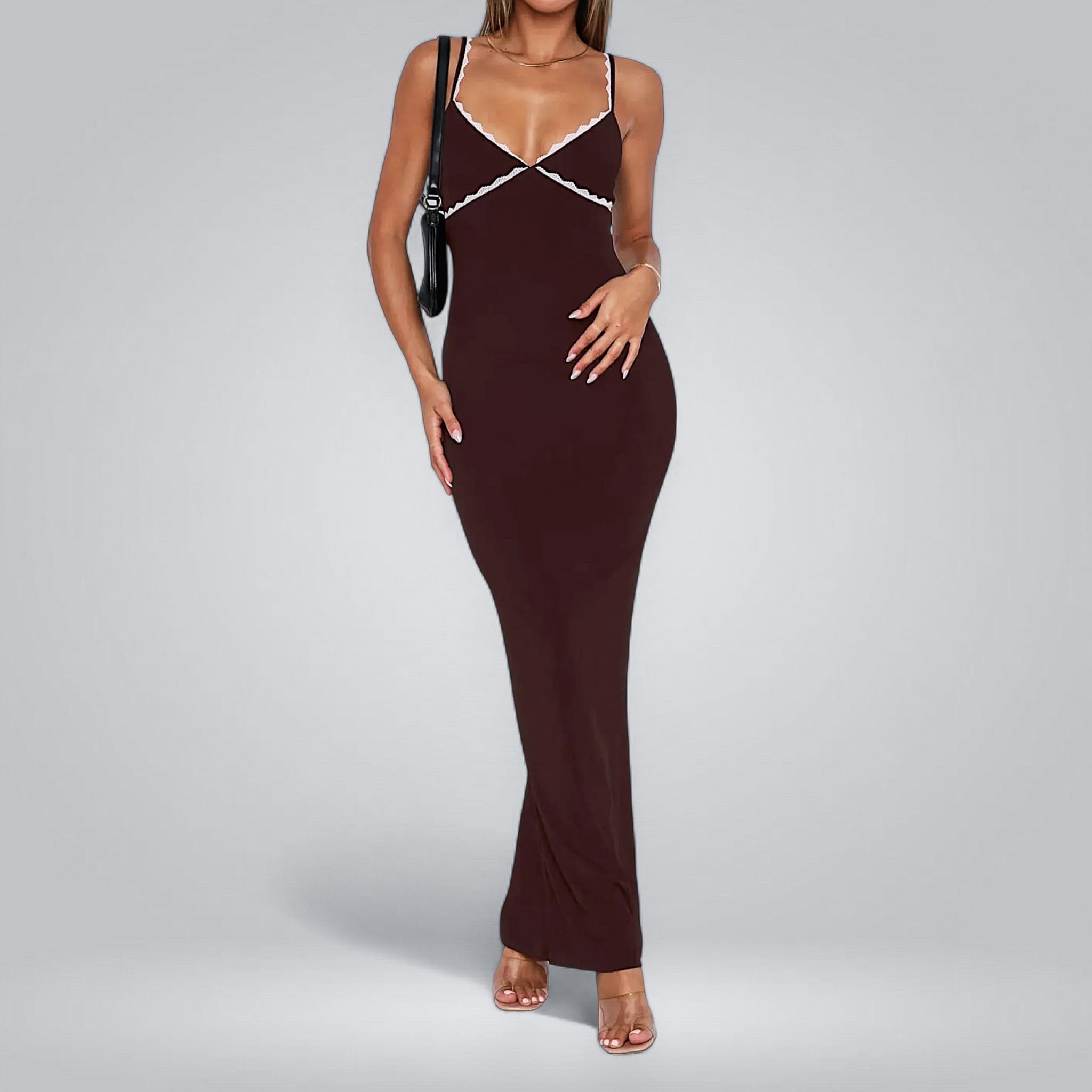Woman wearing a burgundy evening gown with thin straps on a gray background