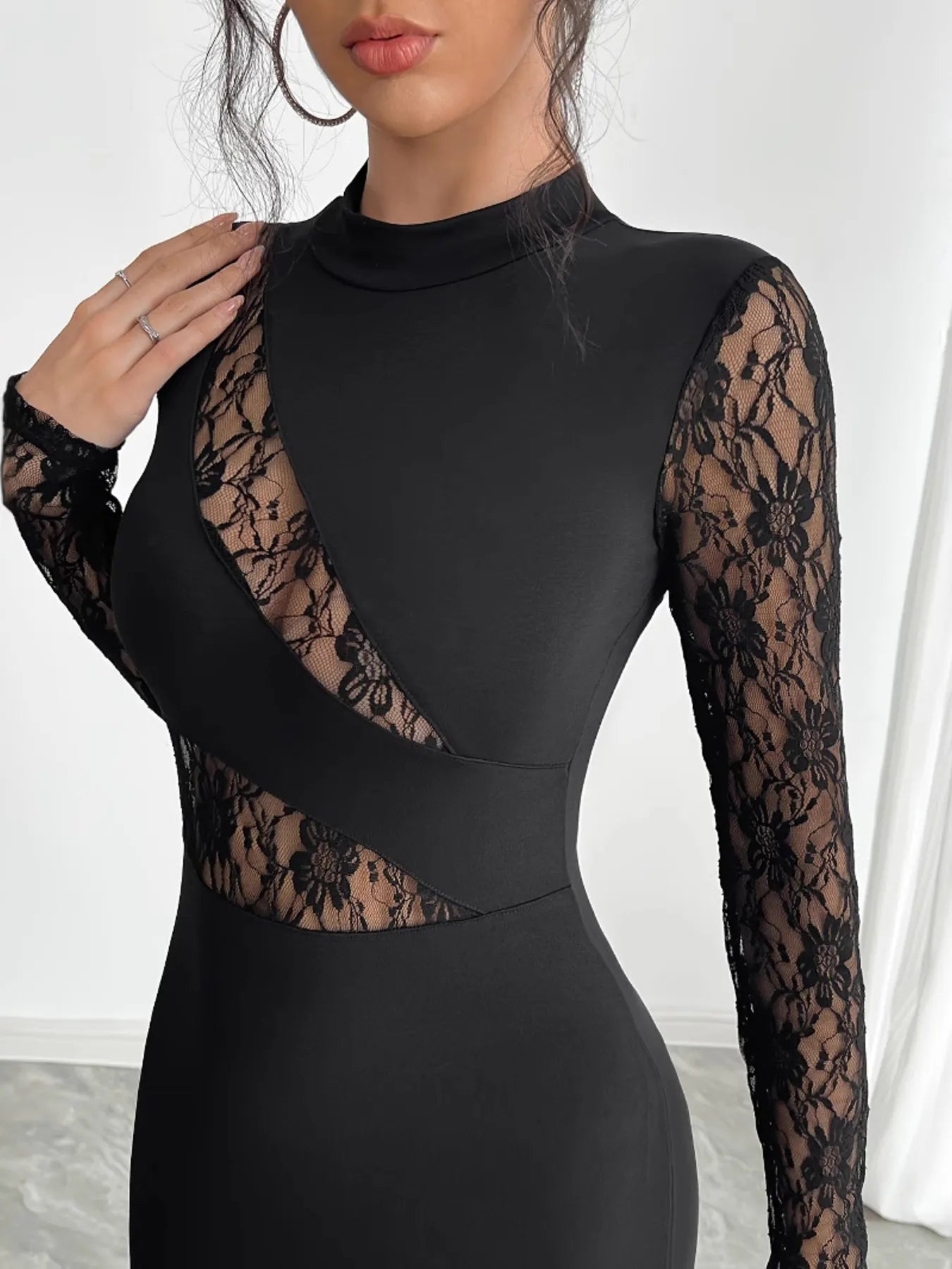 Woman wearing a black lace dress on a gray background