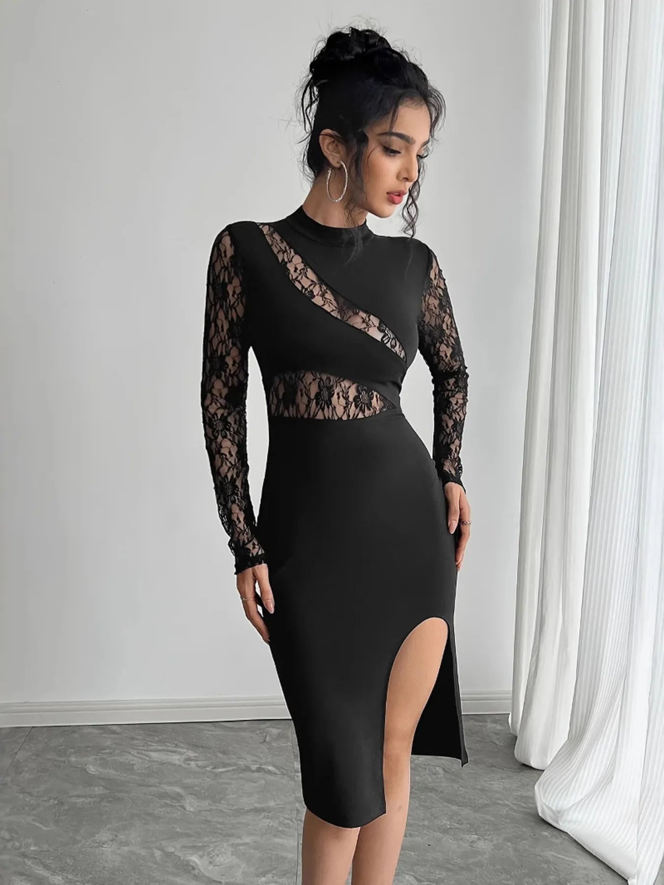 Woman wearing a black lace dress on a gray background